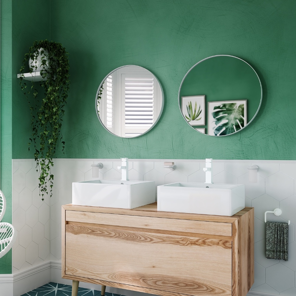 Lifestyle image of two Origins Living City Round 600mm White Mirror's hanging side by side on a green bathroom wall, in front of a double basin setup B375653